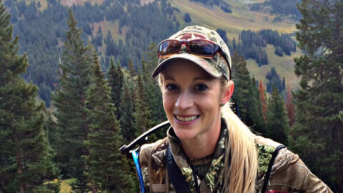blonde female hunter in camo in the mountains