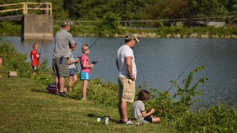 Parents and kids bank fishing on a lake